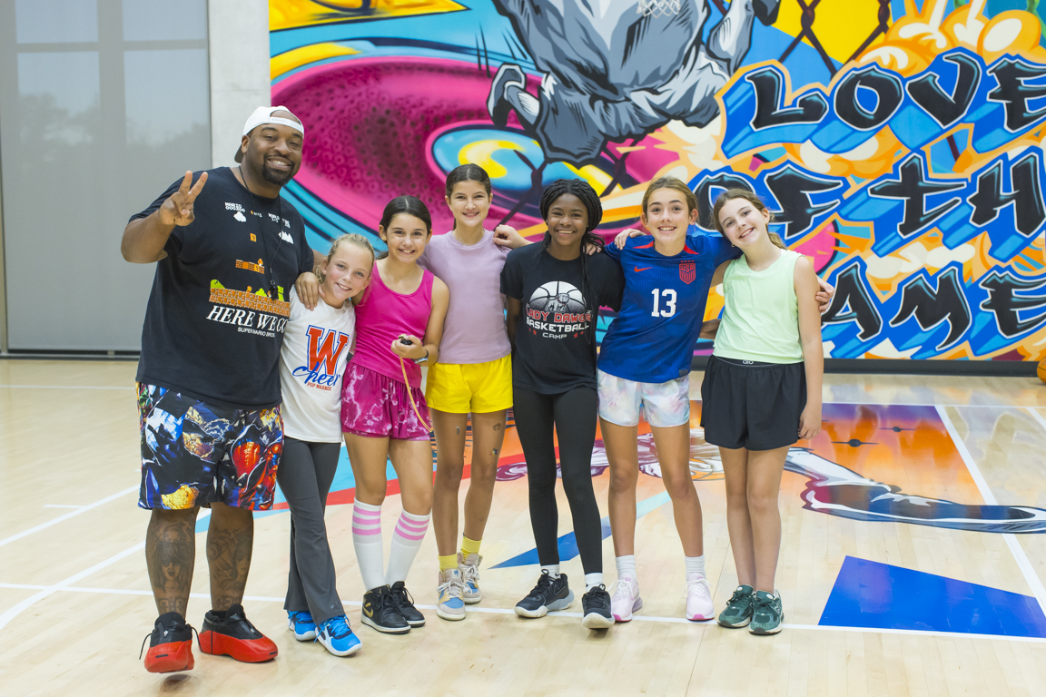 Coach posing with a group of Skills Class athletes after a session.