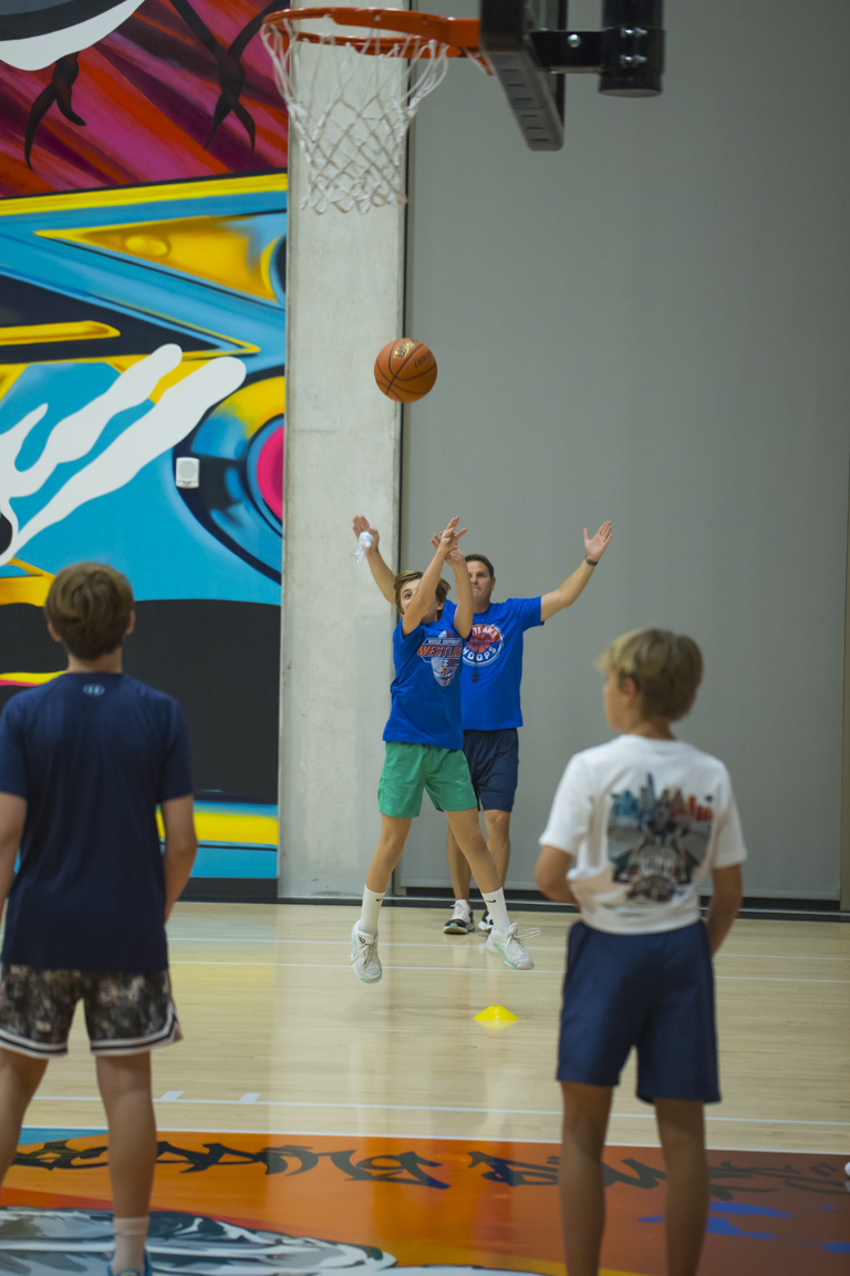 Coach contesting a shooter during a shooting drill at the rim.