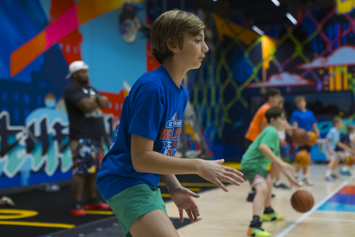Athlete in a blue shirt setting up for a pass during a Skills Class drill.